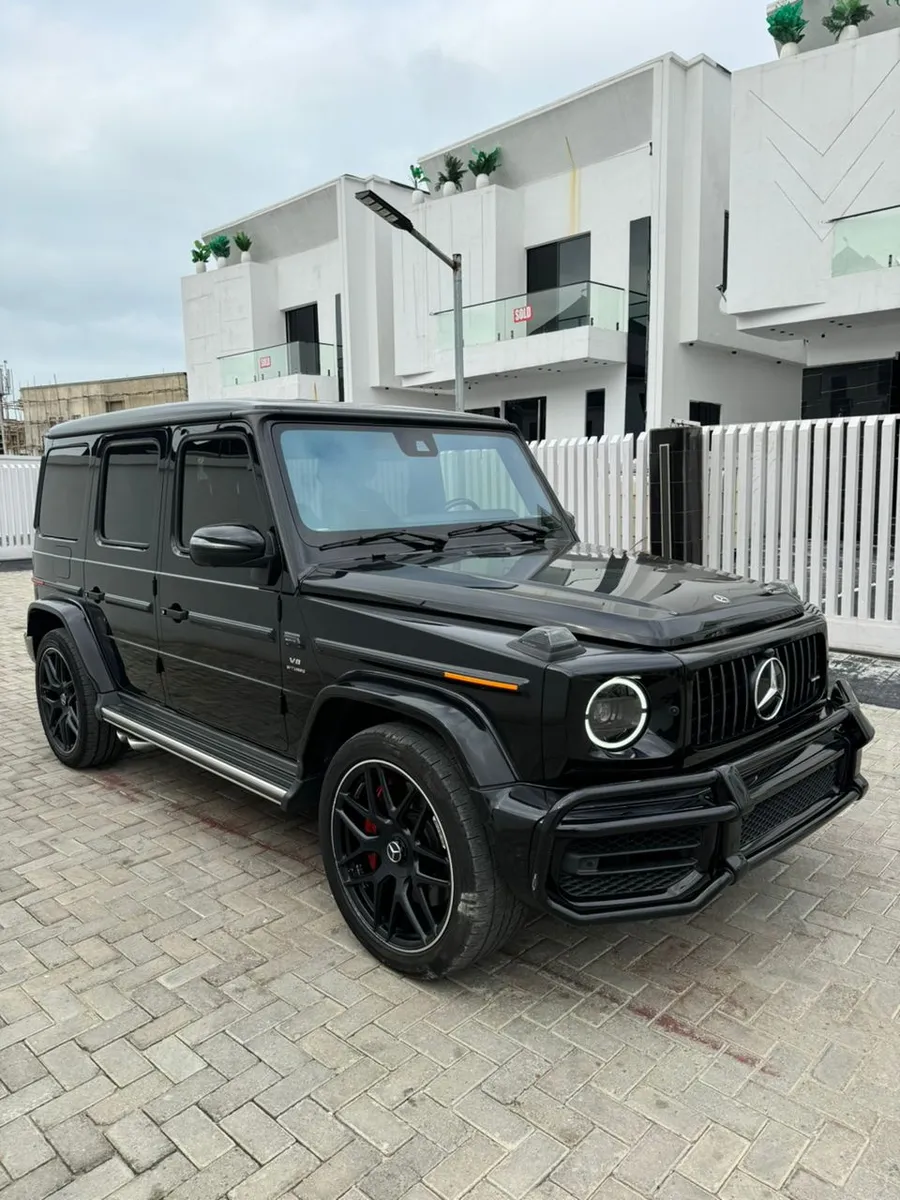 Black Mercedes-AMG G63 parked on paving, front three-quarter view